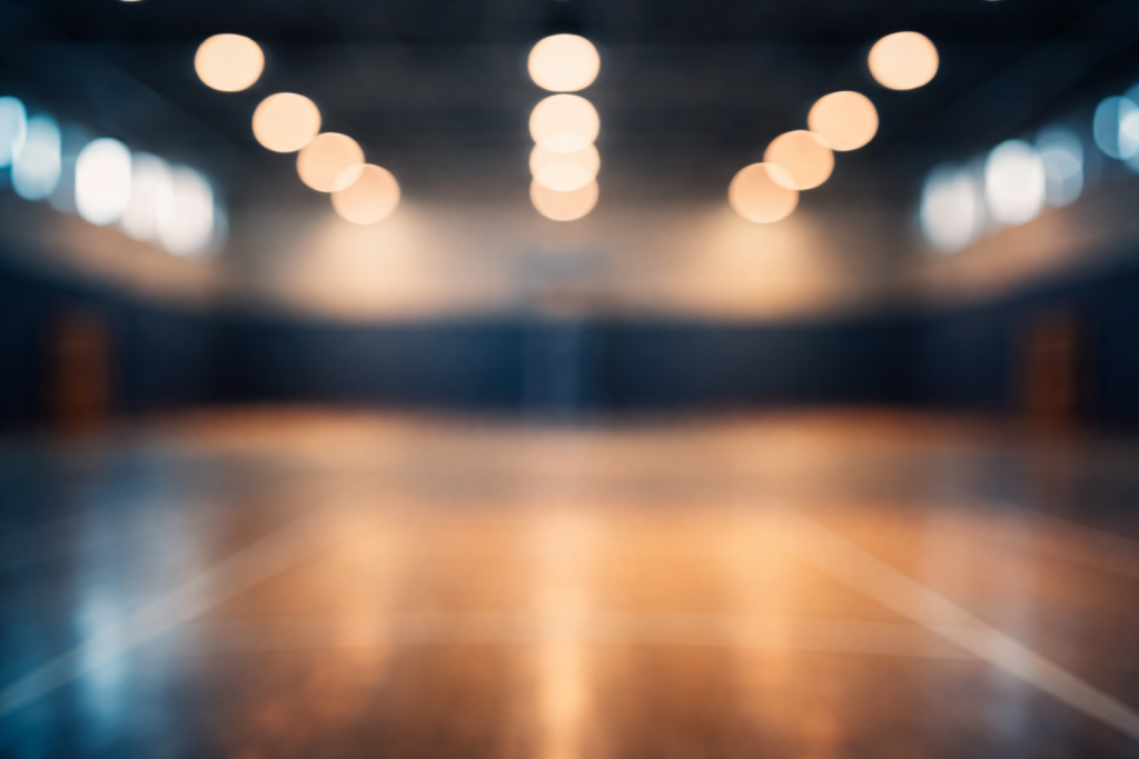 [dark] Baggrund til testimonials: blødt, anonymt billede fra et indendørs sportsmiljø med bokeh, så tekst kan ligge ovenpå uden støj.